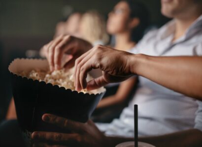 Young people eating popcorn in movie theater
