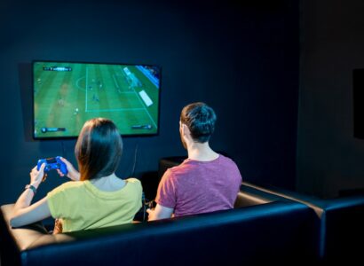 Couple playing football game with gaming console