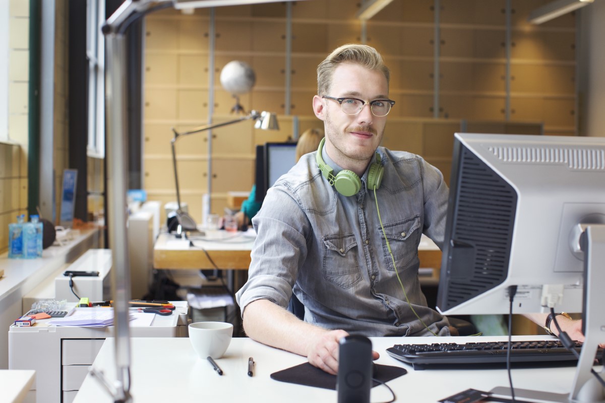 Portrait of young man using computer at office desk