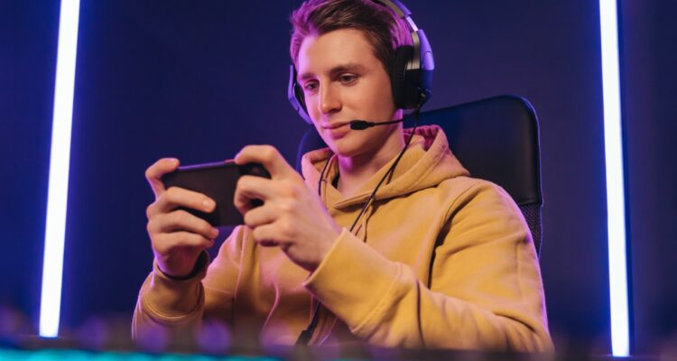 Pro cyber sportsman playing in mobile video game at home